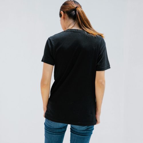Back view of anonymous female in casual clothes with brown hair on light background